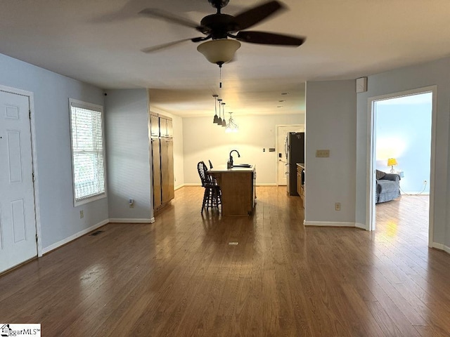 dining space with ceiling fan, baseboards, and dark wood-style flooring