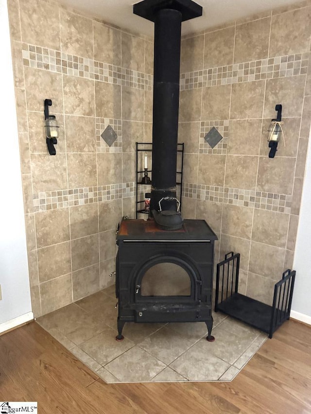 room details featuring a wood stove and wood finished floors