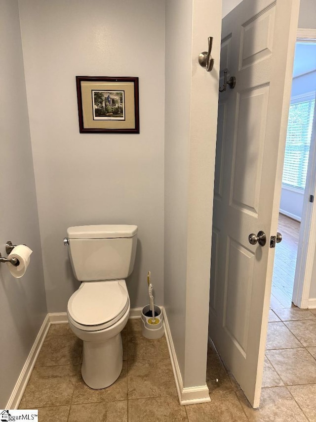 bathroom with tile patterned floors, baseboards, and toilet