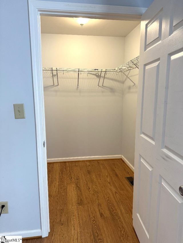 spacious closet featuring wood finished floors and visible vents