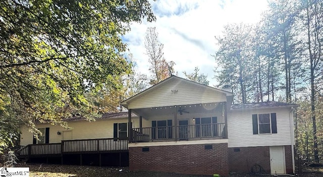 rear view of property featuring brick siding and a ceiling fan