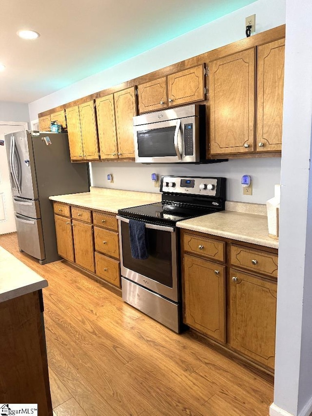 kitchen featuring brown cabinets, light wood-style flooring, recessed lighting, appliances with stainless steel finishes, and light countertops