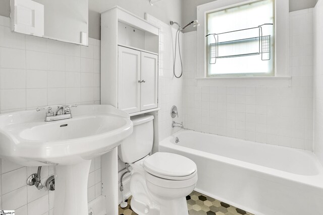 full bath featuring tile patterned floors, toilet, tile walls, and  shower combination