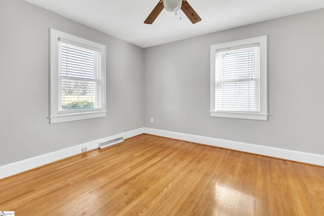 spare room with visible vents, baseboards, wood finished floors, and a ceiling fan