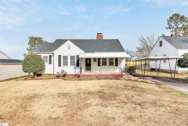 view of front of home with a front yard, fence, a porch, a chimney, and a shingled roof