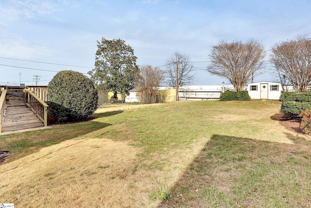 view of yard with a storage shed, an outdoor structure, and fence