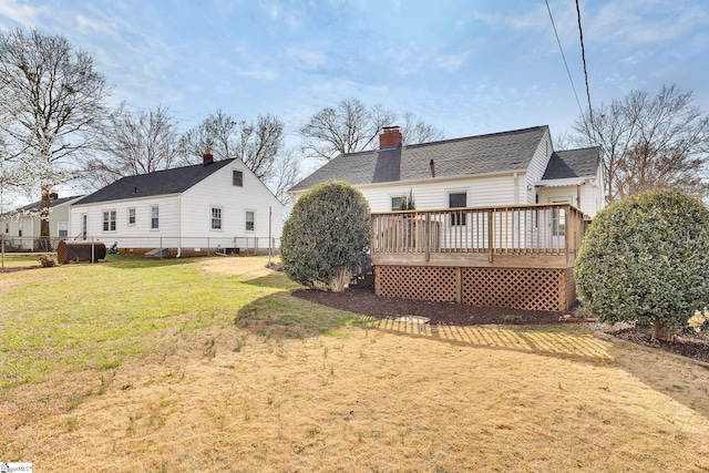 back of house featuring a yard, a wooden deck, heating fuel, and fence