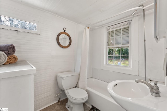 full bathroom with tile patterned flooring, shower / bathtub combination with curtain, toilet, and a sink