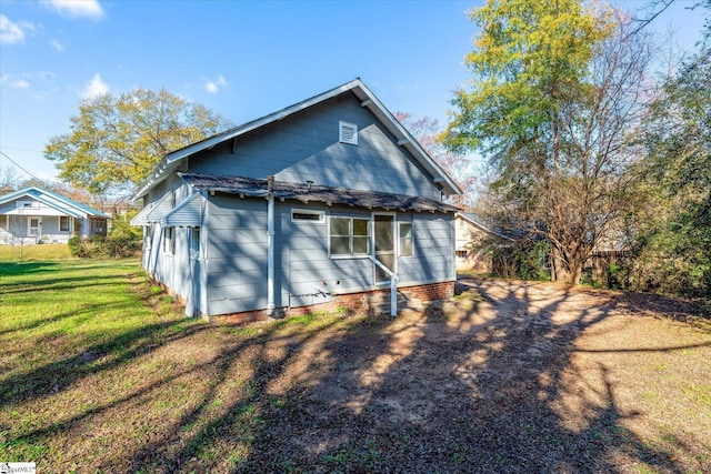 back of property featuring a yard