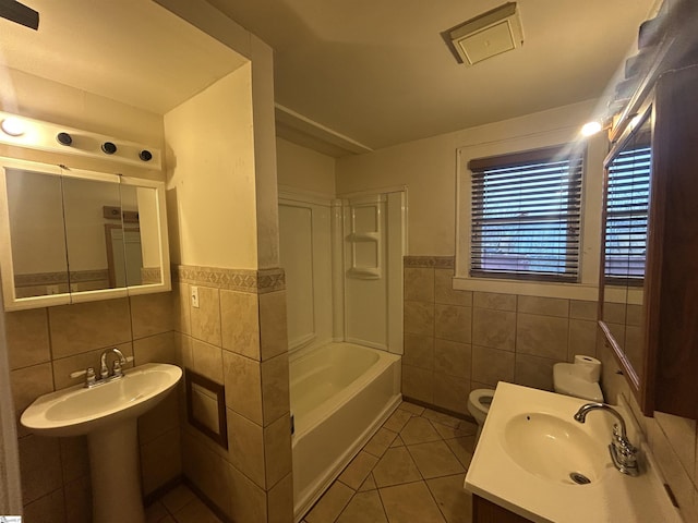 full bathroom with tile patterned flooring, shower / washtub combination, toilet, tile walls, and a sink