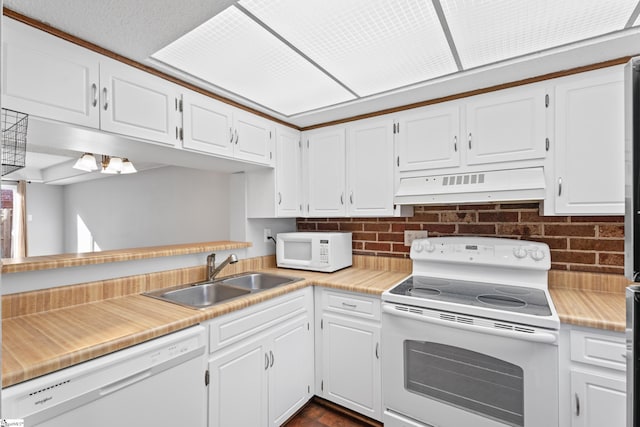 kitchen featuring under cabinet range hood, white appliances, white cabinetry, and a sink