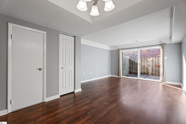 interior space with wood finished floors, baseboards, and a textured ceiling