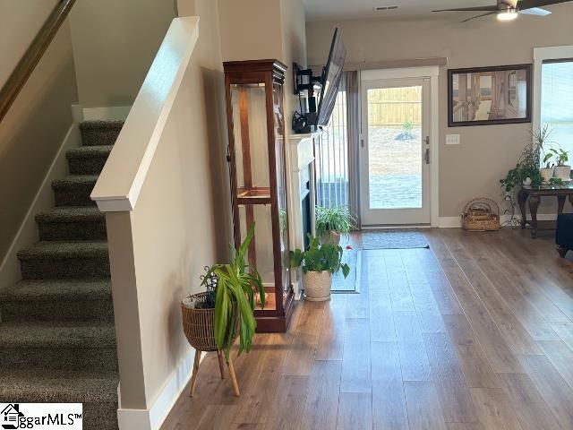 doorway with baseboards, stairs, ceiling fan, and wood finished floors