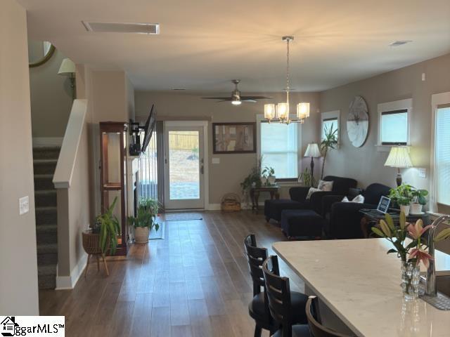 dining room featuring stairway, wood finished floors, visible vents, and a wealth of natural light