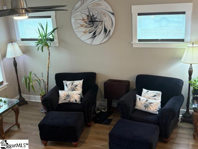 living area with baseboards and wood finished floors