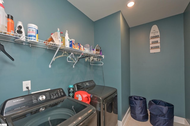 clothes washing area featuring tile patterned floors, washing machine and dryer, and laundry area