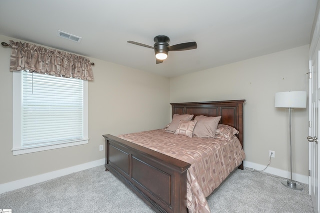 bedroom with visible vents, light carpet, and baseboards