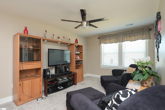 living area featuring visible vents, ceiling fan, light colored carpet, and baseboards