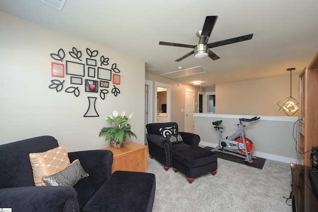 carpeted living area with attic access and baseboards