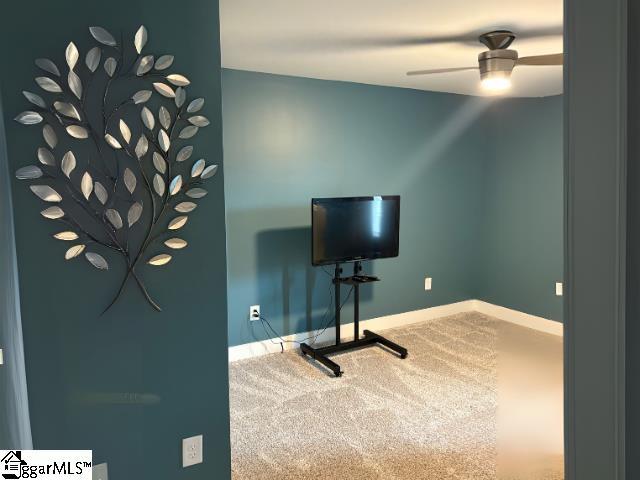 interior space with ceiling fan, baseboards, and carpet floors