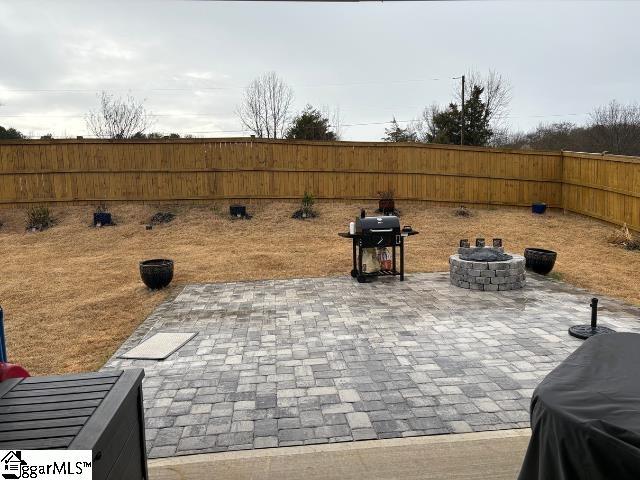 view of patio / terrace featuring area for grilling, a fenced backyard, and an outdoor fire pit