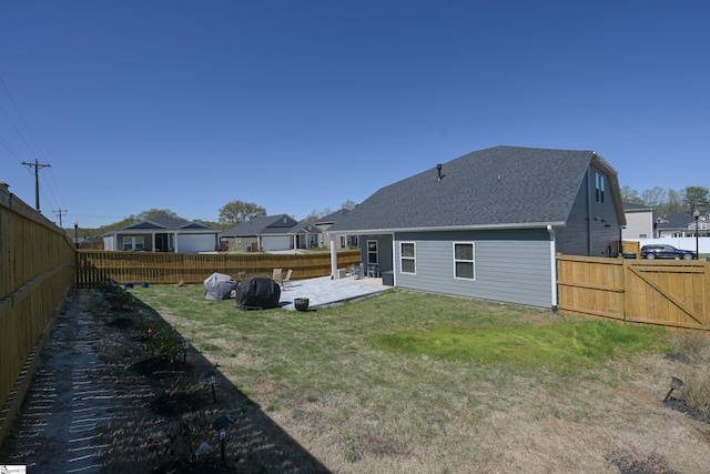 back of house featuring a yard, a patio, a residential view, and a fenced backyard