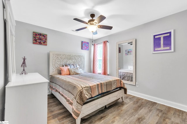 bedroom featuring visible vents, wood finished floors, baseboards, and ceiling fan