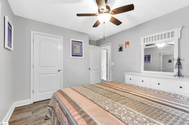 bedroom featuring ceiling fan, baseboards, and wood finished floors