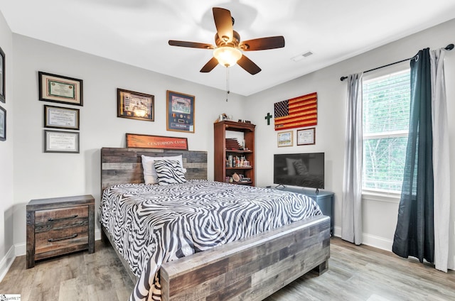 bedroom featuring visible vents, baseboards, and wood finished floors