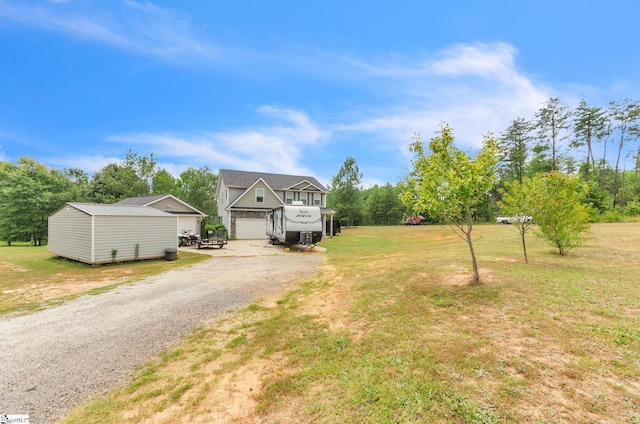 view of front of home featuring a garage, driveway, an outdoor structure, and a front lawn