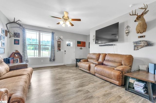 living room with a ceiling fan, wood finished floors, and baseboards