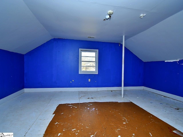 additional living space featuring visible vents, baseboards, and vaulted ceiling