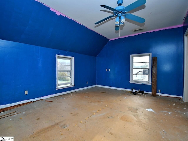 additional living space with vaulted ceiling, plenty of natural light, a ceiling fan, and baseboards