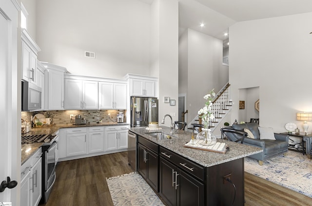 kitchen featuring dark wood-style flooring, white cabinetry, stainless steel appliances, and a sink