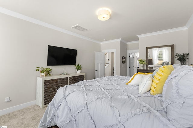 carpeted bedroom featuring crown molding, baseboards, and visible vents