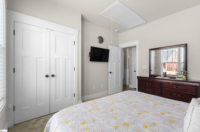 bedroom with attic access, carpet, a closet, and baseboards