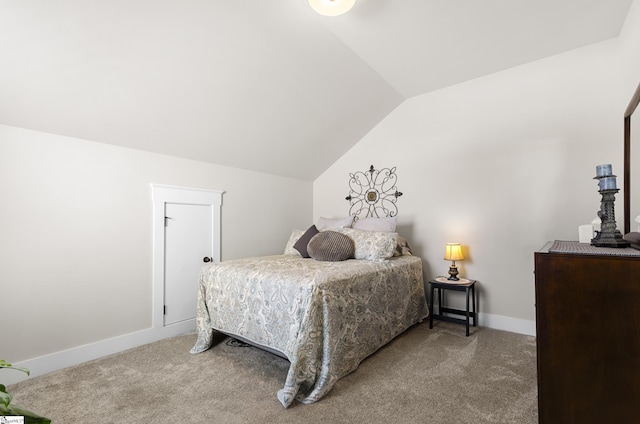 carpeted bedroom with vaulted ceiling and baseboards