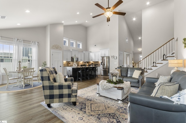 living room featuring visible vents, recessed lighting, stairs, and wood finished floors