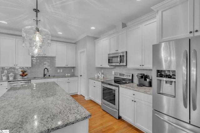 kitchen featuring a sink, stainless steel appliances, white cabinets, crown molding, and light wood finished floors