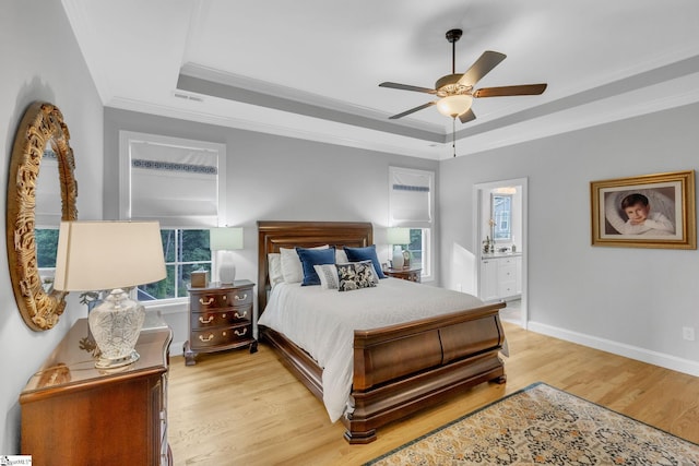 bedroom with ceiling fan, baseboards, ornamental molding, light wood-style floors, and a raised ceiling