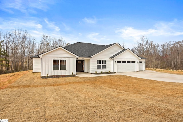 view of front of property featuring board and batten siding, an attached garage, roof with shingles, and concrete driveway