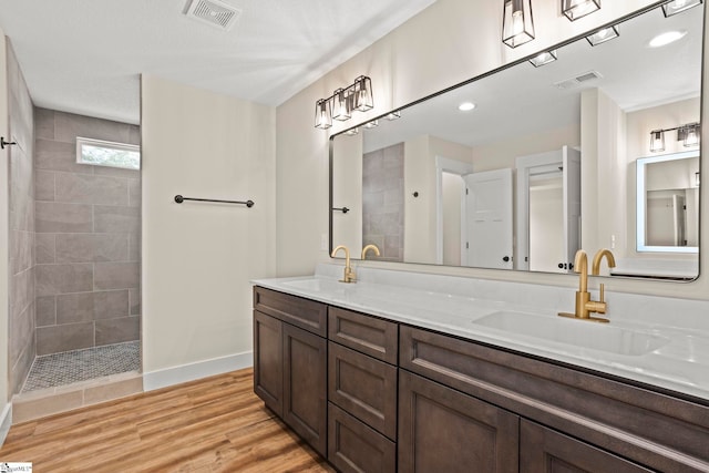 full bathroom with a sink, visible vents, and wood finished floors