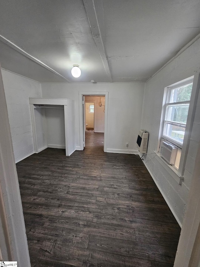 interior space featuring heating unit, dark wood-style floors, baseboards, and cooling unit