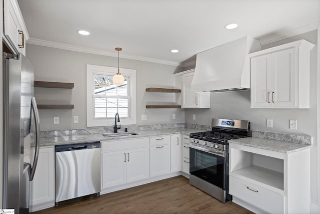 kitchen with open shelves, premium range hood, appliances with stainless steel finishes, and a sink