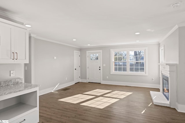 unfurnished living room with baseboards, dark wood-type flooring, and ornamental molding