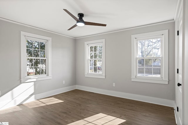 spare room featuring baseboards, dark wood-style floors, and crown molding