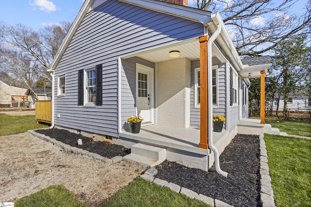 view of property exterior featuring a porch and a chimney