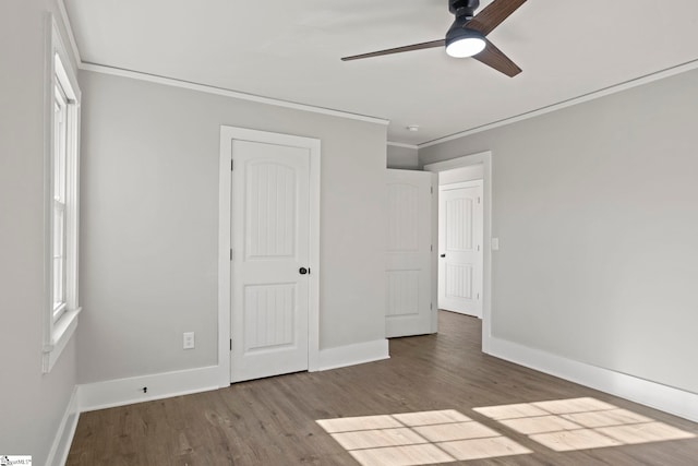 unfurnished bedroom featuring wood finished floors, baseboards, a closet, and ornamental molding