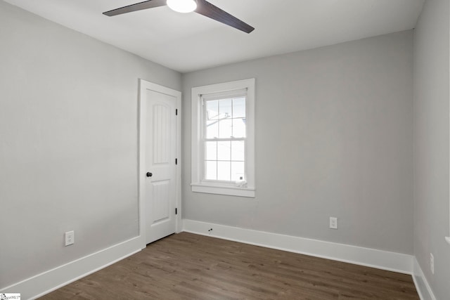 unfurnished room featuring ceiling fan, baseboards, and dark wood finished floors