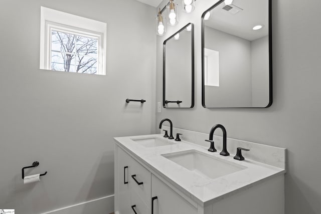 bathroom with double vanity, visible vents, and a sink